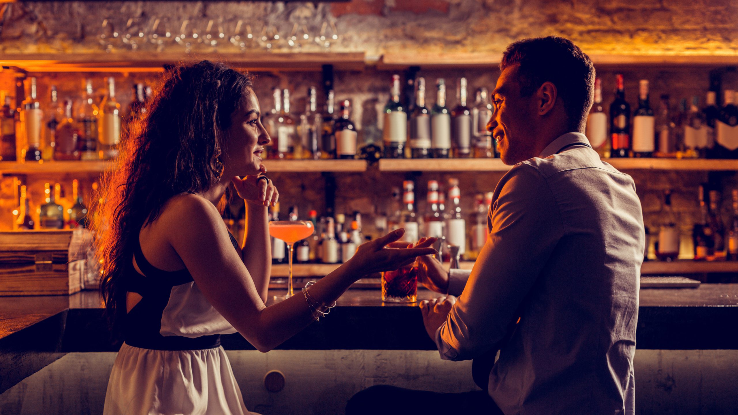Young lovely couple sitting at the bar stand and talking